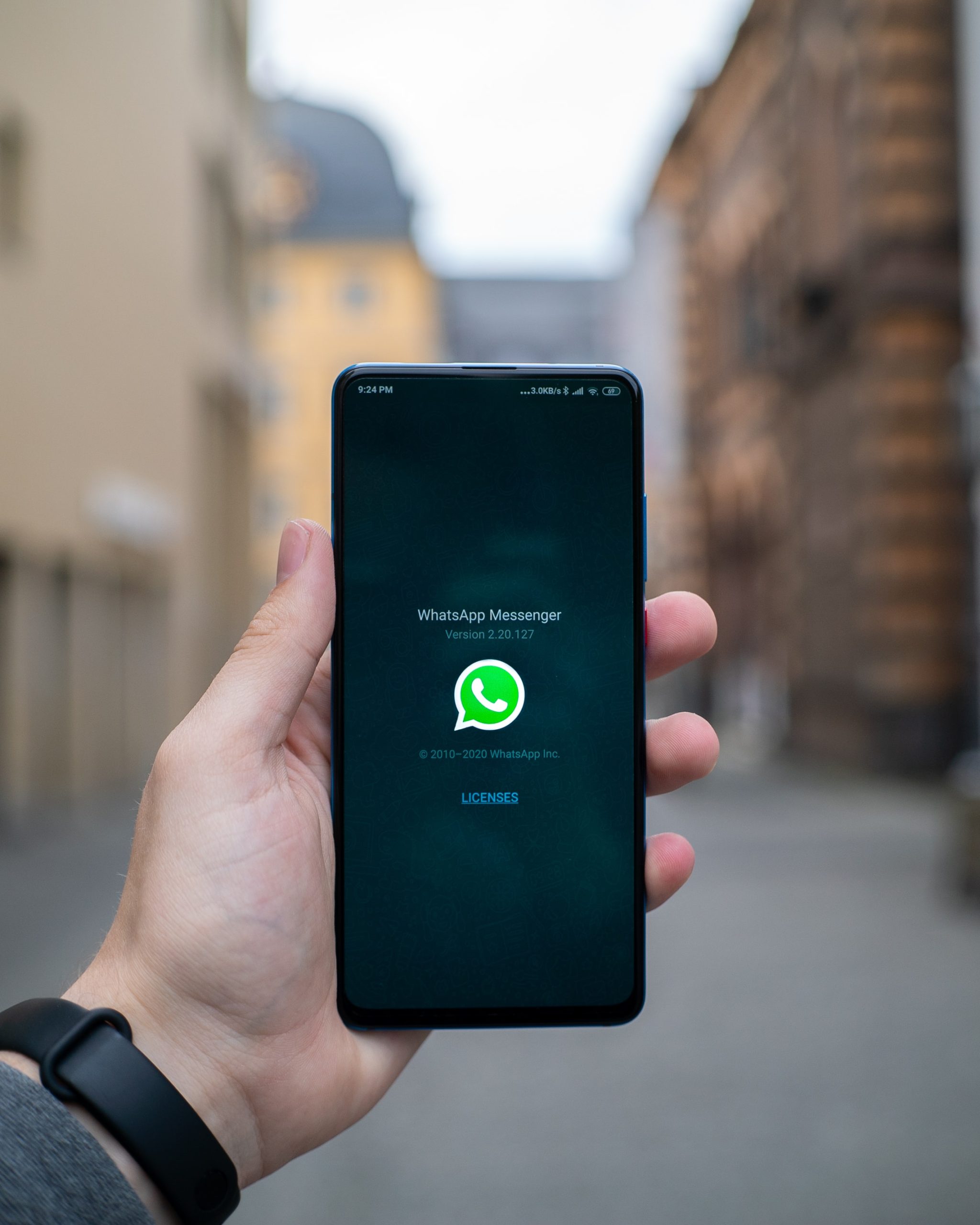 Photograph of a hand holding a smartphone which screen presents Whatsapp.